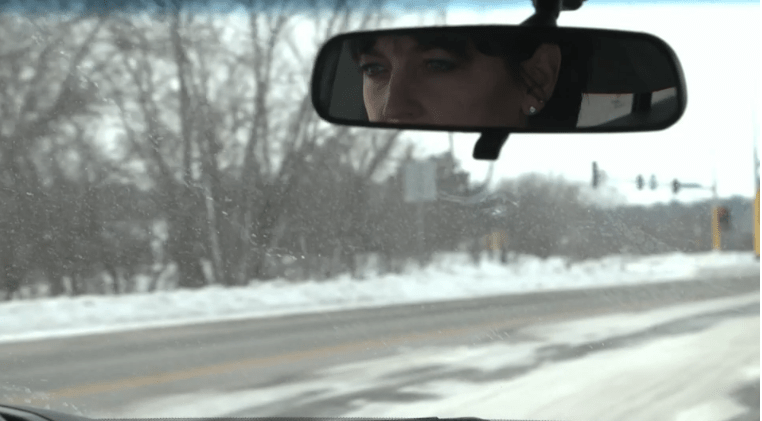 Julie's image in the rear view mirror as they journey to receive treatment